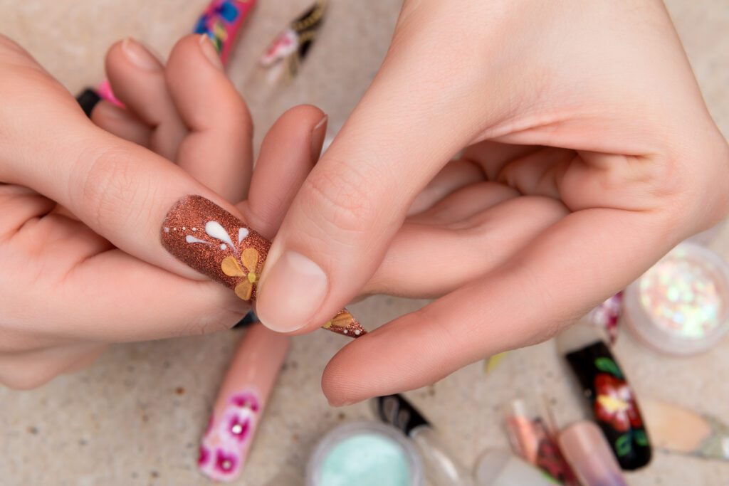 girl trying artificial nails tips with flower nail design