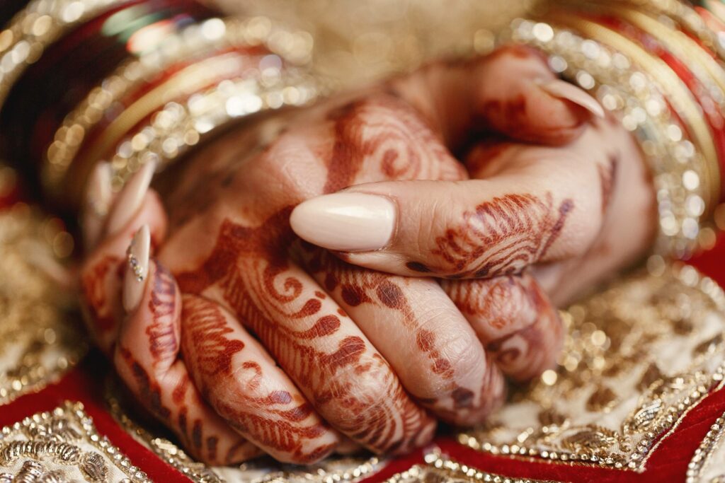 closeup long bride s fingers covered with mehndi lying 1 1