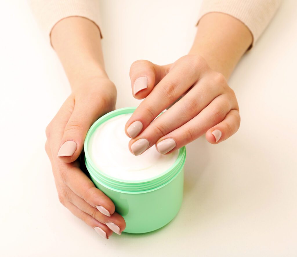 female hands holding jar cream isolated white